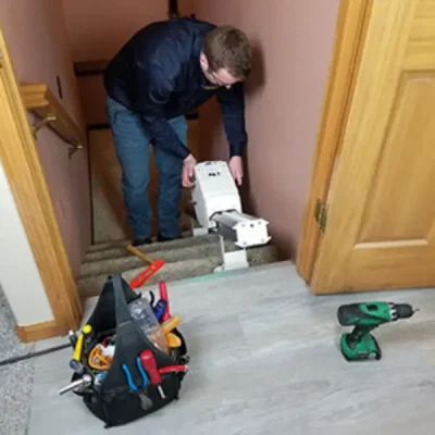 Man repairing a stairlift an essential mobility aid